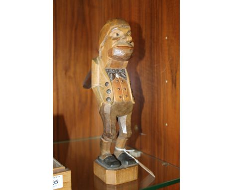 A CARVED BLACK FOREST NOVELTY NUT CRACKER IN THE FORM OF A MAN, stood with his hands in his pockets, painted with coloured hi