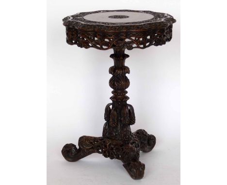 A Burmese hardwood circular table carved with foliage on an ornate central column and tri-point base, diameter 57cm.