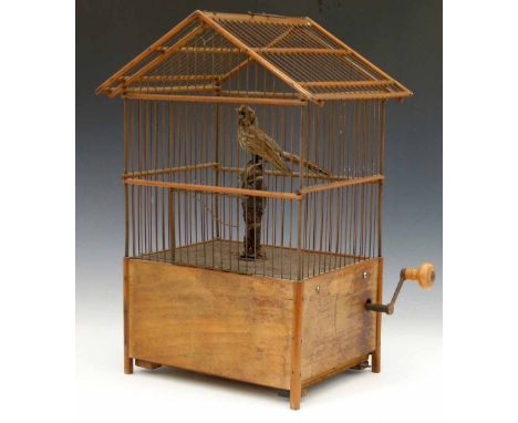 Singing bird in a cage automaton, rectangular with wood and wire sides, winding by a cranked handle, overall height 43cm. Con