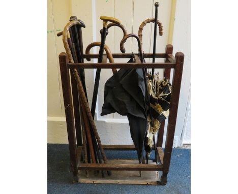 An Edwardian oak three section hall stick stand including coconut palm, malaca and Ceylonese ebony walking canes and umbrella