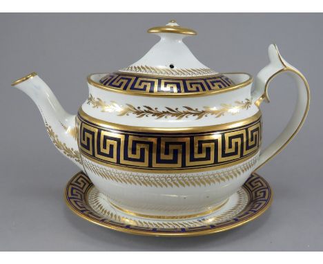 An early nineteenth century Spode porcelain teapot, cover and stand, c. 1810-15. It is decorated in blue and gilding with a G
