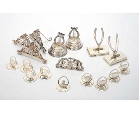 
	
		 A collection of silver and silver mounted menu holders, to include: a set of eight Edwardian menu holders by Horace Woo