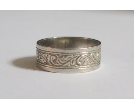 A Platinum Band engraved with scrolling foliate band and inner inscription, size K, 7mm wide, 5.6g 