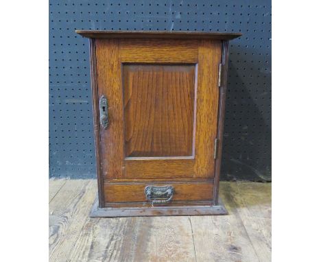 A Victorian Oak Pipe Smokers Cabinet with inset embossed tin panel to the inside of the door with Art Nouveau decoration 