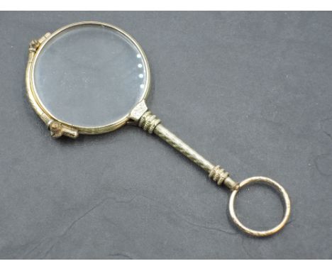 A yellow metal lorgnette of traditional form, spring working, no marks