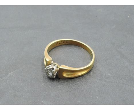 A diamond solitaire dress ring, approx 0.065ct in an illusionary mount to moulded shoulders on a yellow metal loop stamped 18