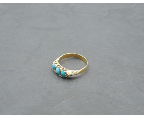 A Victorian ring having a trio of oval turquoise in a gallery mount on a yellow metal loop, marks worn but tests as 18ct gold