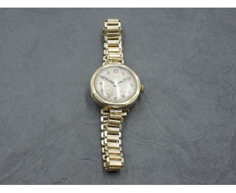 A lady's vintage 9ct gold Rolex wrist watch having Arabic numeral dial to engine turned face in gold case on a rolled gold br