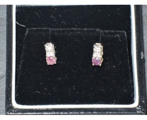 A pair of diamond chip and amethyst stud earrings in 9ct gold mounts, approx 1g