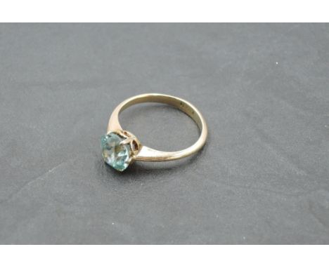 An aquamarine solitaire ring in a claw set mount on a yellow metal loop stamped 15ct, size N &amp; approx 2.9g (stone bearing