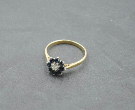 A sapphire and diamond chip cluster dress ring on a yellow metal loop stamped 18ct, size N/O &amp; 2.4g