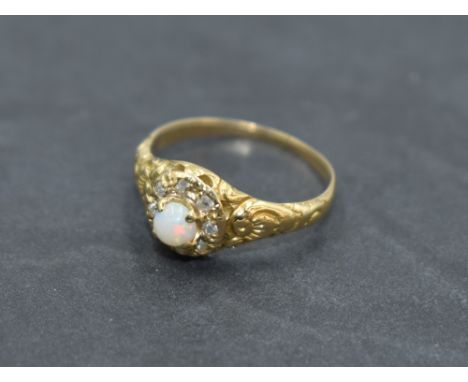 A Victorian opal and diamond cluster ring having central opal cabochon within a surround of rough cut diamonds in heavily mou