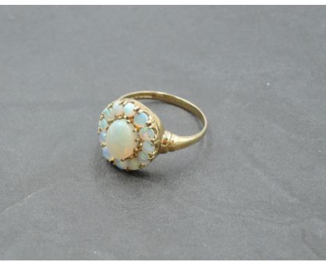 An oval opal cluster ring in a stepped claw mount on a 9ct gold loop, size R &amp; approx 1.7g