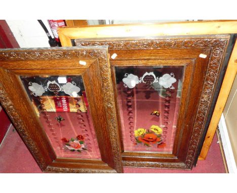 A pair of bevelled engraved and painted wall mirrors, in carved oak frames, each 83 x 52cm; reproduction advertising wall mir