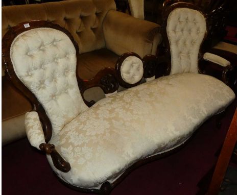 A mid-Victorian floral carved mahogany framed double hump-back sofa, having cream floral buttoned silk damask upholstery, wid