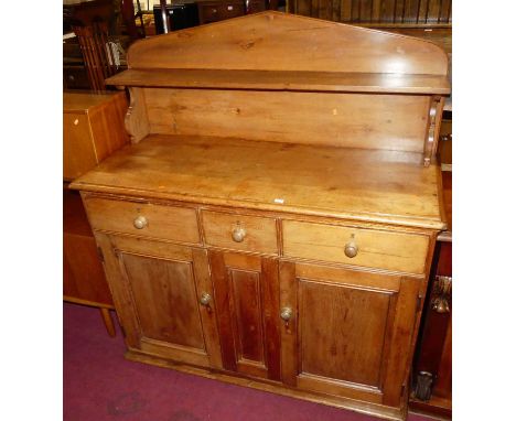 A Victorian stained pine ledge back side cupboard, having a raised single shelf superstructure over three frieze drawers and 