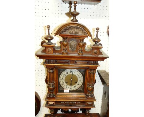 A late Victorian walnut wall clock, housed in an architectural case