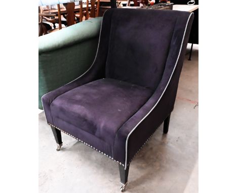 Two 'knocker back' lounge chairs in midnight blue velveteen fabric with grey piping, chromed ring knockers, caps and casters 