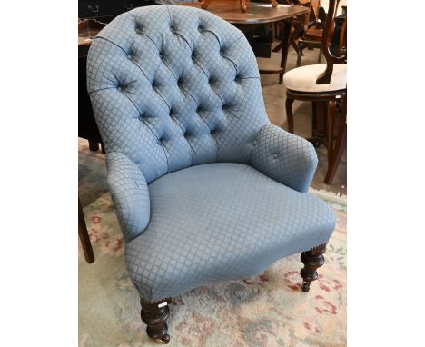 A Victorian mahogany framed nursing chair, blue button back upholstery on turned front legs with casters 