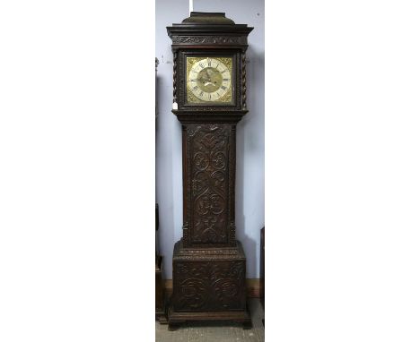 Carved oak eight day longcase clock, the caddy hood top with barley twist columns enclosing a brass dial with mask spandrels,