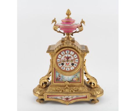 19th century French gilt metal mantel clock, with pink porcelain plaques, the urn finial over a circular dial and panel depic