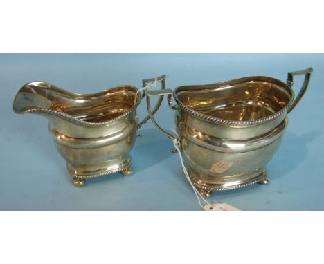 A Georgian plain cream jug and sugar basin with gadrooned borders, on ball feet, Sheffield 1915, ___8.5oz.