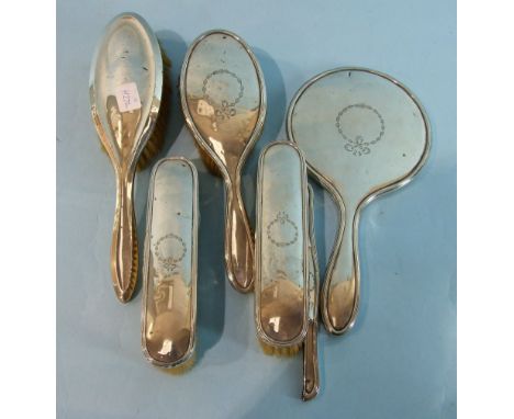 A five-piece silver dressing table set with ribbon garland decoration, comprising mirror, three brushes and comb mount, Birmi