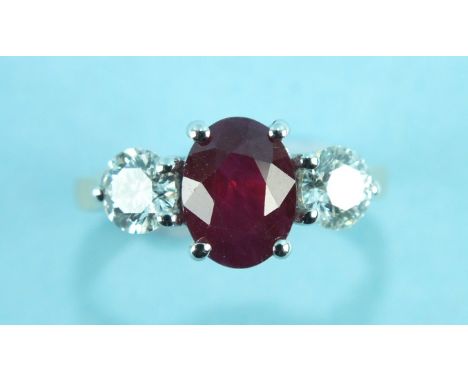 A ruby and diamond ring, claw set an oval ruby of approximately 2cts between two brilliant cut diamonds approximately 0.52 ct