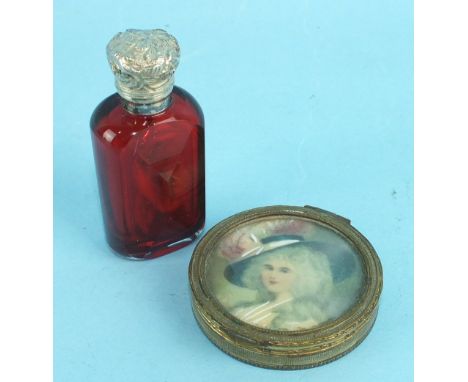 A small yellow metal compact, the lid inset a portrait of an 18th century lady and a small red glass scent bottle with white 