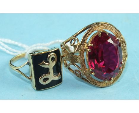 A 9ct gold ring set a large synthetic red stone, size O, 6.1g and an unmarked gold ring with 'L' motif, size K, 3.3g.