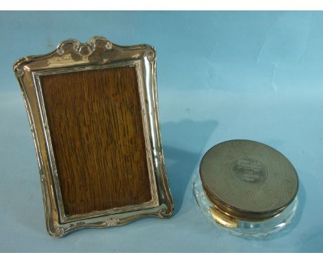 An Edwardian silver photograph frame with scrolling decoration, 19.5 x 14cm, Birmingham 1904 and a modern silver-topped powde