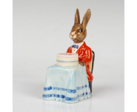 A bunny dressed in a formal bright red jacket and blue bow tie, seated at a table with a birthday cake. Royal Doulton backsta