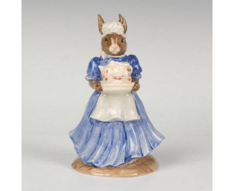 A figure of a motherly parent wearing antique clothing and carrying a tray with a tea pot and cup. RDICC. This item has its o