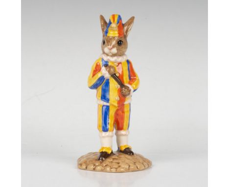 A jester wearing a yellow, red, and blue outfit and hat, and is holding a stick. Part of the Punch and Judy Collection. Royal