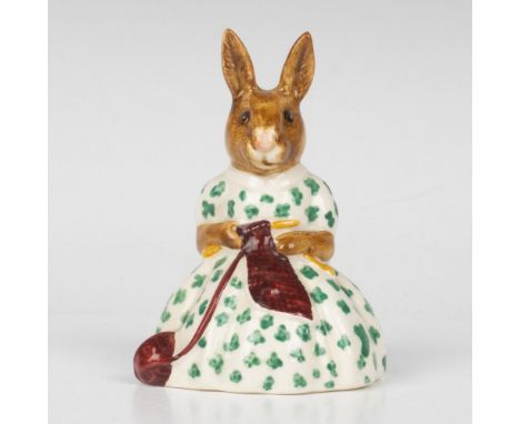 A figure wearing a white and green floral dress, knitting a dark red scarf. Royal Doulton backstamp. Artist: W. HaywardIssued