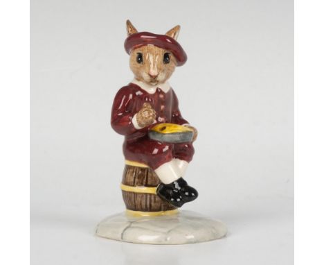 A figure of a young bunny sitting on a barrel while holding a pie. Dressed in antique dark red clothing. Part of the Nursery 