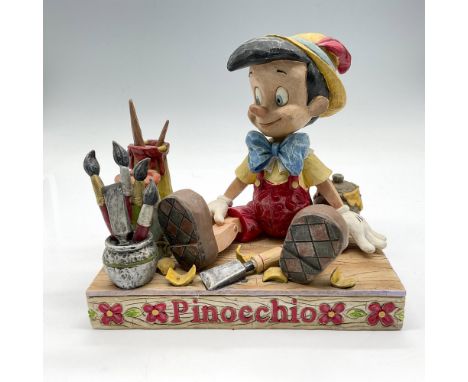 Disney Traditions blends enchantment and American folk art to create this porcelain figure surrounded by all the tools to cre