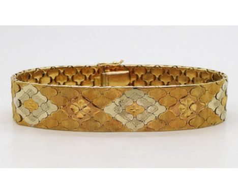 A THREE COLOUR GOLD BRACELET Italian made, stamped 750, with engraved flower pattern to the interlocking tile pattern links, 