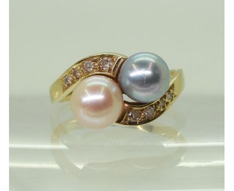 A TWIN PEARL RING mounted in 18ct gold, with estimated approx 0.11cts of brilliant cut diamonds set to the shoulders, further