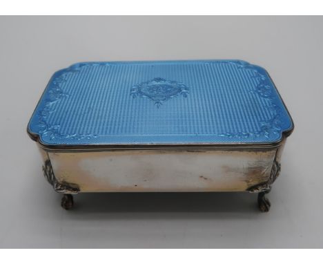 A GEORGE V SILVER GUILLOCHE ENAMEL JEWELLERY BOX by William Comyns, London 1927, of shaped rectangular form, the lid decorate