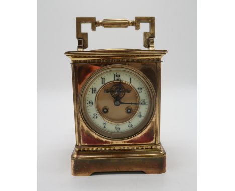 A LARGE BRASS FRENCH CARRIAGE CLOCK the dial centre inset with the visible lever escapement and enamel chapter ring with blac