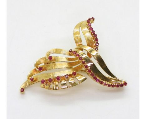 A RUBY BROOCH set in bright yellow metal, with engraved texture. Dimensions 3.5cm x 4.5cm, weight 10.6gms retailed by De Silv