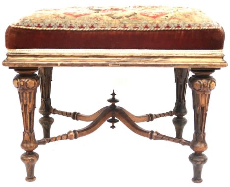 A 19TH CENTURY WALNUT FRAMED STOOL  with tapestry upholstered seat on extensively carved turned supports joined by crossed ca