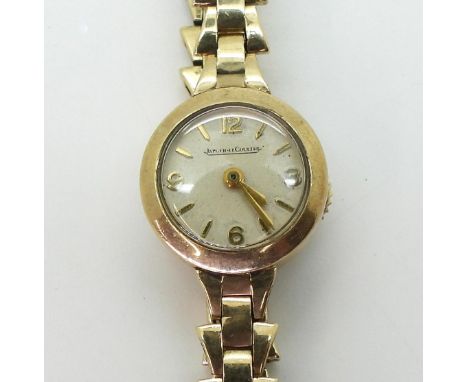 A LADIES JAEGER LECOULTRE WATCH in 9ct gold with a fancy link strap, the cream dial with Arabic and baton numerals and hands,