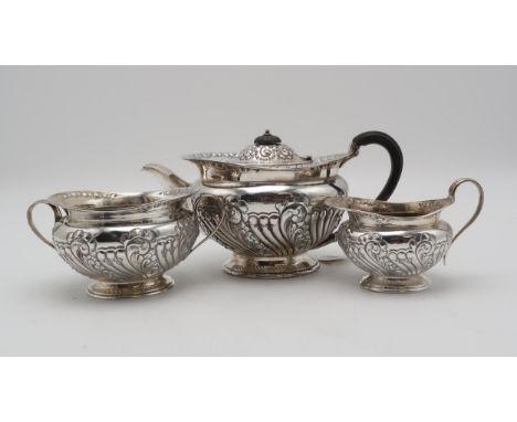 AN EDWARDIAN THREE PIECE SILVER TEA SERVICE by Atkins Brothers, Sheffield 1904, of squat form, with engraved and engine turne