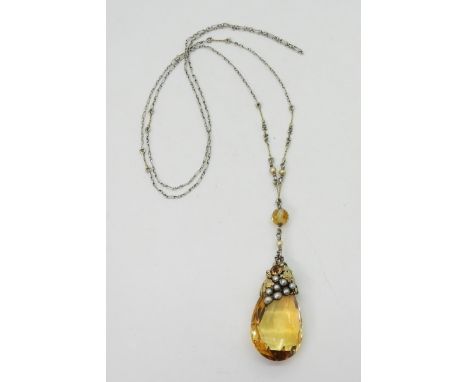 A CITRINE VINE PENDANTProbably made by DORRIE NOSSITER. With a grape and vine theme, the yellow metal vine leaves and tendril