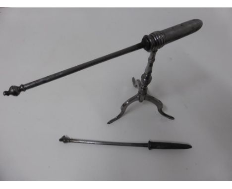 A WELL MADE STEEL TRIPOD STAND ON SPADE FEET WITH HOLDER FOR HEATING IRONS/ POKERS , TOGETHER WITH 2 HEATING IRONS, THOUGHT T