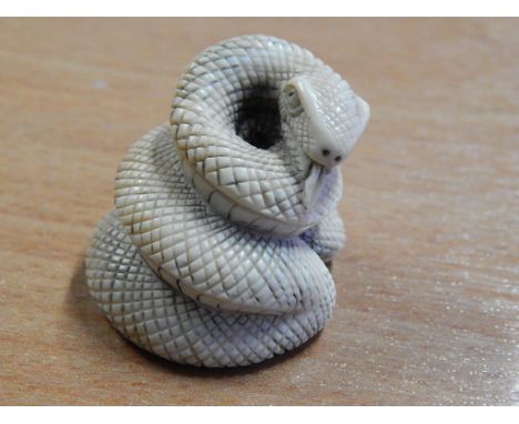 AMBER NETSUKE IN THE FORM OF A CAT AND AN IVORY DITTO MODELLED AS A COILED SNAKE