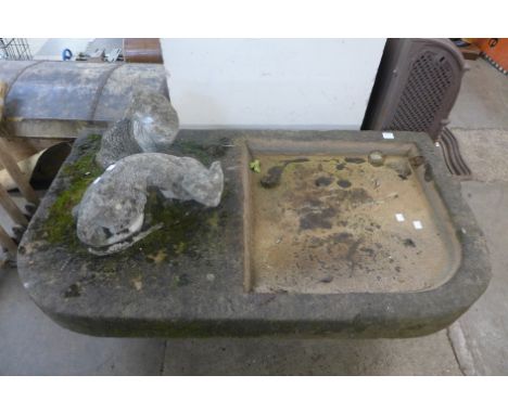 A large stone garden trough and two cat ornaments