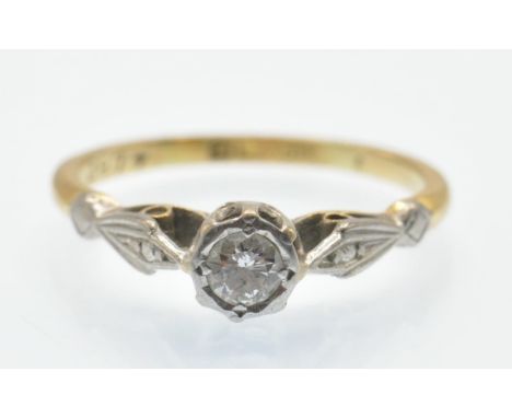 A hallmarked 18ct gold and diamond solitaire ring. The ring set with a single diamond in a raised pierced illusion setting ha